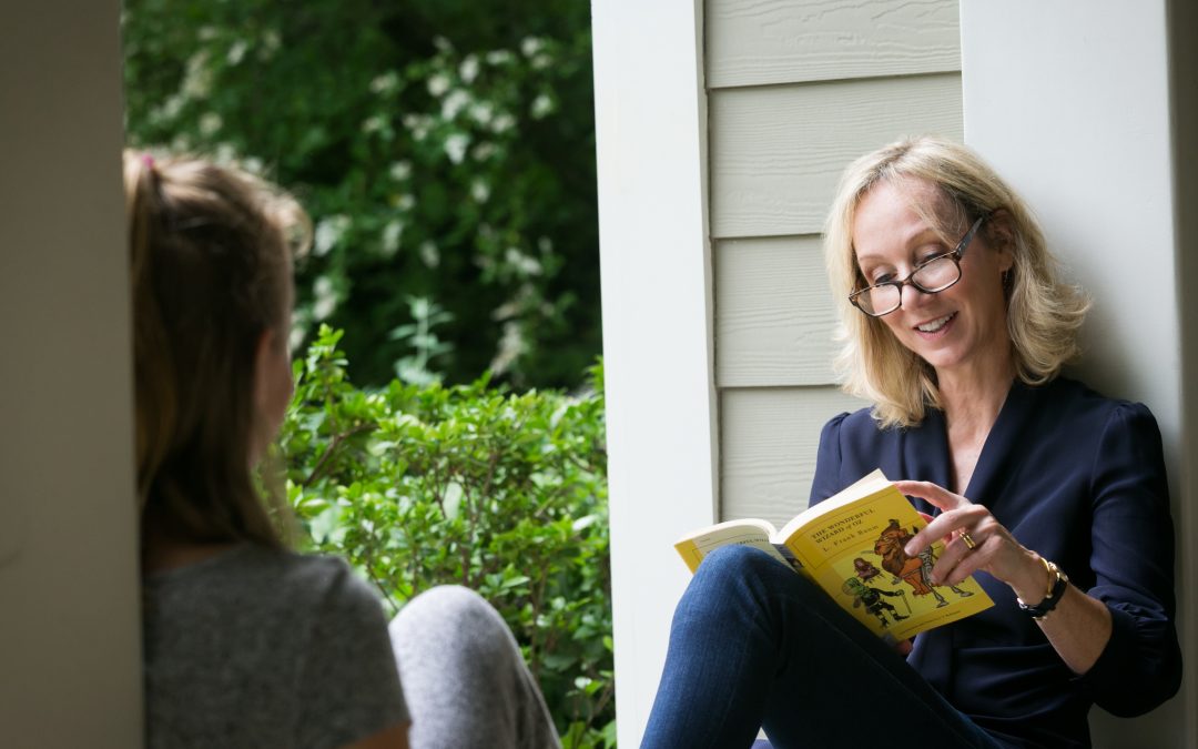 Meghan Cox Gurdon reading aloud to a child outdoors.