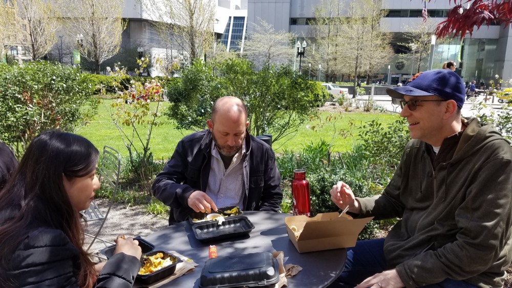 Three people eating lunch outside